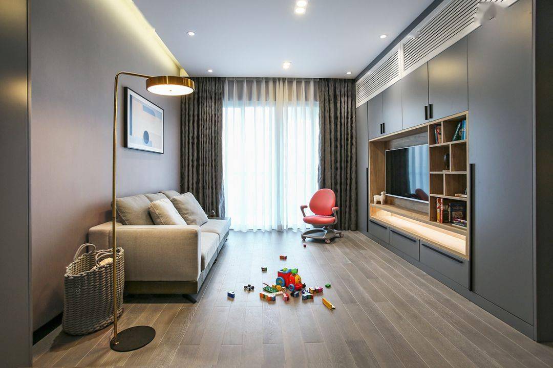 今天分享的是一套建筑面積102平米的現代輕奢風三居室案例，屋主夫妻和女兒、母親一家四口人居住，整體來說是比較緊湊的剛需三房案例，設計師以輕松、時尚的灰色調作為主色，搭配格調滿滿的木質家具，營造出簡約、輕奢的感覺。    平面布置圖    入戶玄關和餐廳連在了一起，利用了入戶門側方的墻面來做上一整墻的柜子，把鞋柜和餐邊柜結合在一起使用，更為省空間。    復古的木質餐桌椅到灰色調的背景，金屬質感的吊燈，整個餐廳看起來非常有格調感。在餐桌椅側方加上隔板的設計，增強儲物能力。    位于餐廳另一側的就是客廳空間了，客廳的茶幾被舍棄，中間留空方便作為孩子的娛樂區，米色布藝沙發和暖灰色背景墻讓人感覺更加溫馨。    客廳的電視背景墻則是被利用起來做了收納，整墻的柜子留空電視周邊的部分區域，加上藏光之后使用更方便，看起來也更大氣。    廚房內部的櫥柜延續了客餐廳的柜子顏色，深灰色的大理石墻磚搭配灰色的啞光地磚，整個廚房看起來很有現代感。    臥室選擇了以藍灰色為主，在臥室頂部吊頂內加上藏光，用吊燈、臺燈等代替主燈，讓臥室看起來更為簡潔。    在主臥室里還有一個迷你的衣帽間，U字形布局的柜子把角落空間充分用上。衣帽間外的床頭柜改成了梳妝臺，使用起來更加方便。    老人房選擇了榻榻米床組合衣柜和書桌的設計，榻榻米的安全性會更高一些，加上一張書桌也方便屋主母親看看書。    衛生間內部是三角形的布局方案，鉆石形的淋浴房做在了轉角處，兩側擺放洗手臺和馬桶。洗手臺上方的鏡柜做了藏光的設計，看起來更時尚。